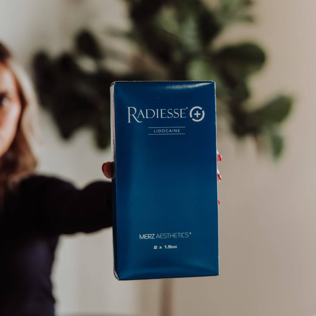 Woman sowing Radiesse pack in camera | Wellness Co. | Zeeland, MI